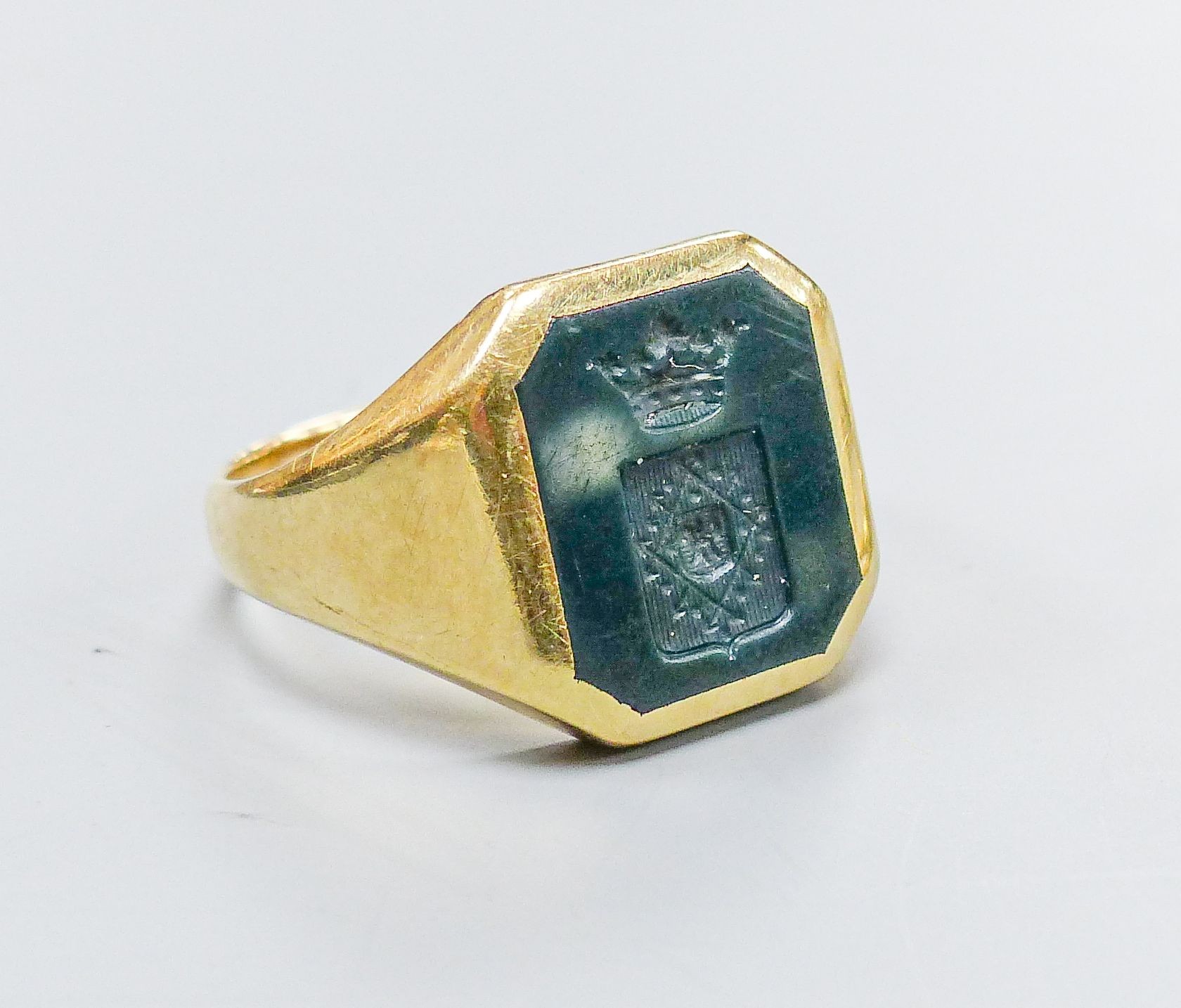 A yellow metal signet ring, inset octagonal intaglio chalcedony matrix, size U, gross 8.3 grams and a yellow metal oval-link bracelet, with box clasp, 10.5 grams.